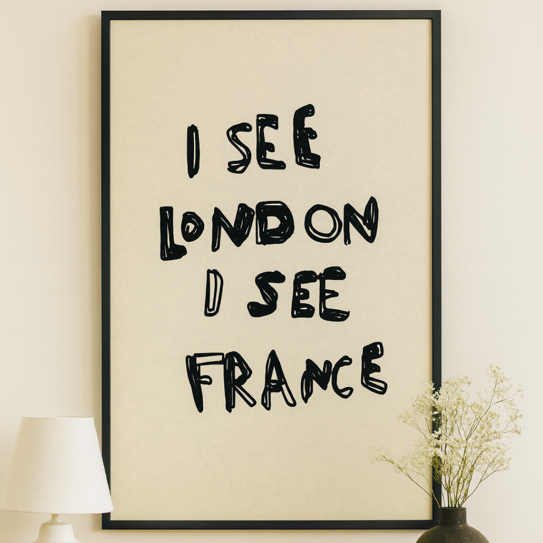 Framed artwork with text 'I SEE LONDON I SEE FRANCE' on a wall above a wooden table.