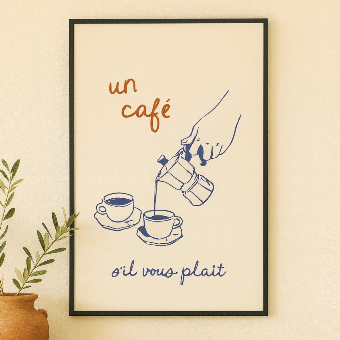 Framed french artwork of a hand pouring coffee into cups with text on a wall above a wooden table.
