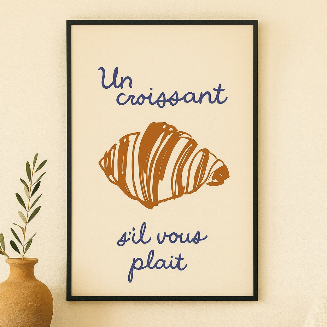 Framed french artwork with a croissant illustration and text on a wall above a wooden shelf.